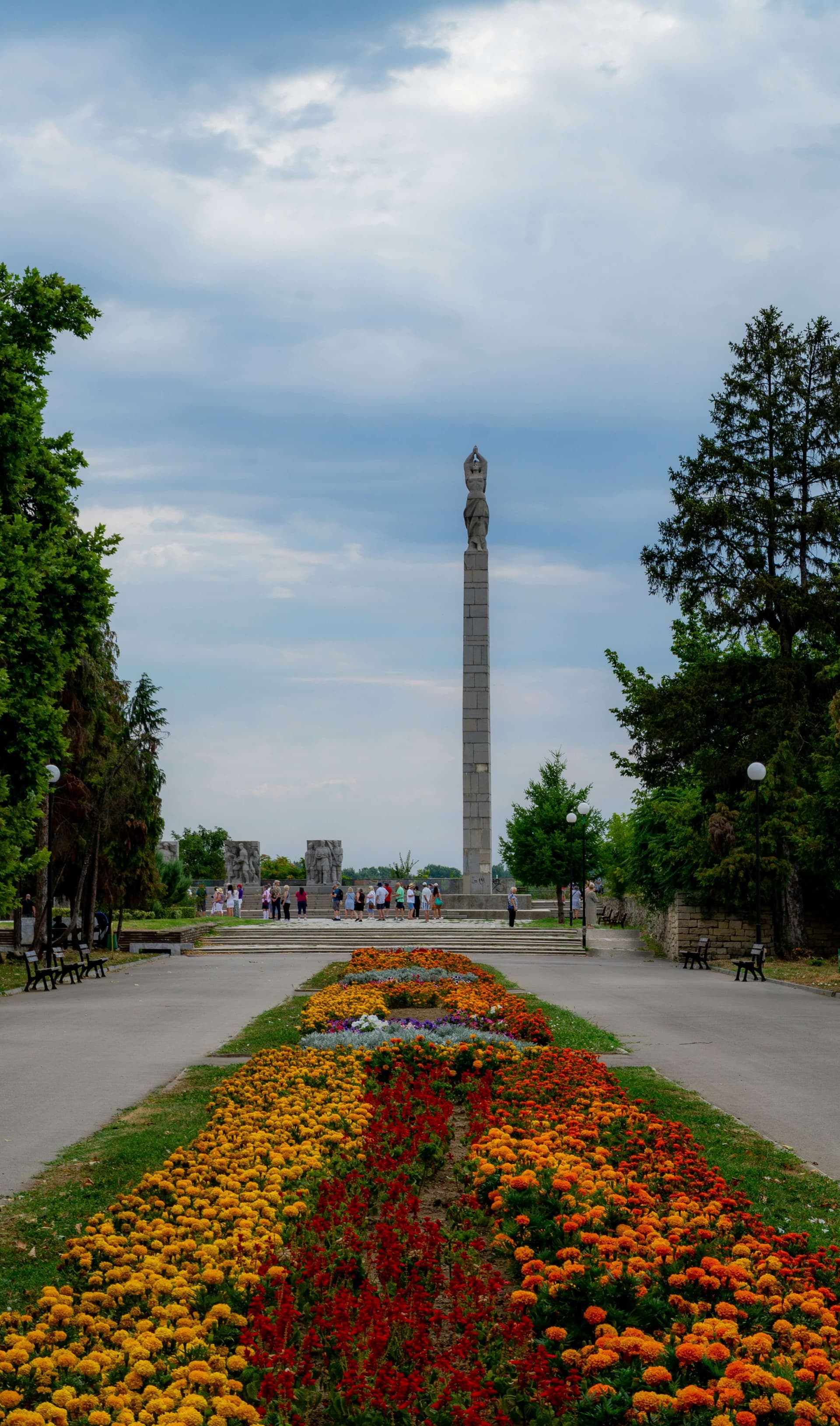 A tall memorial obelisk above formal flower beds in a Vidin park