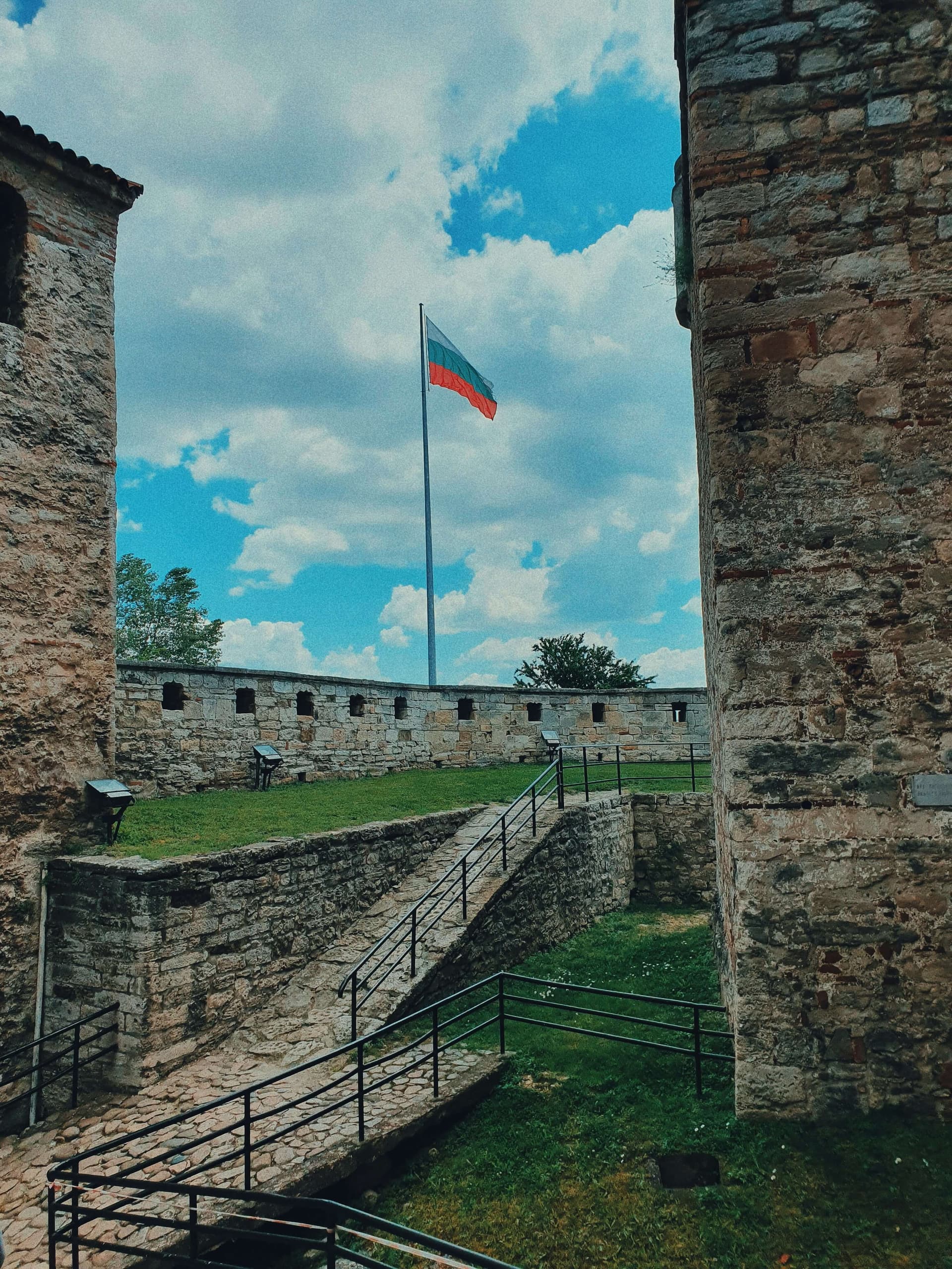 Inside the fortress: grassed courtyards, embrasured walls and the Bulgarian flag