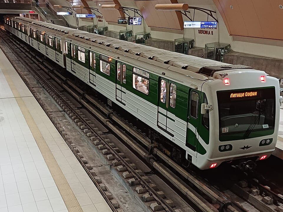 A green and white Sofia Metro train at Serdika II station, its front display reading Sofia Airport